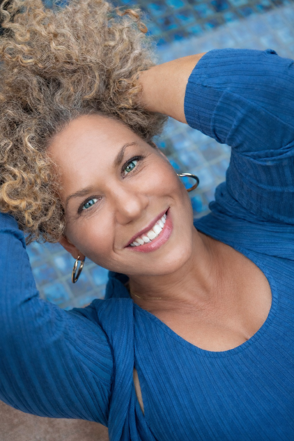 Hopi smiling in a vivid blue portrait